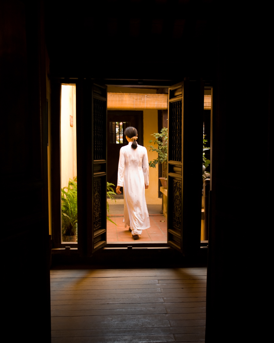 Woman walking through doorway in a traditional wooden Asian house