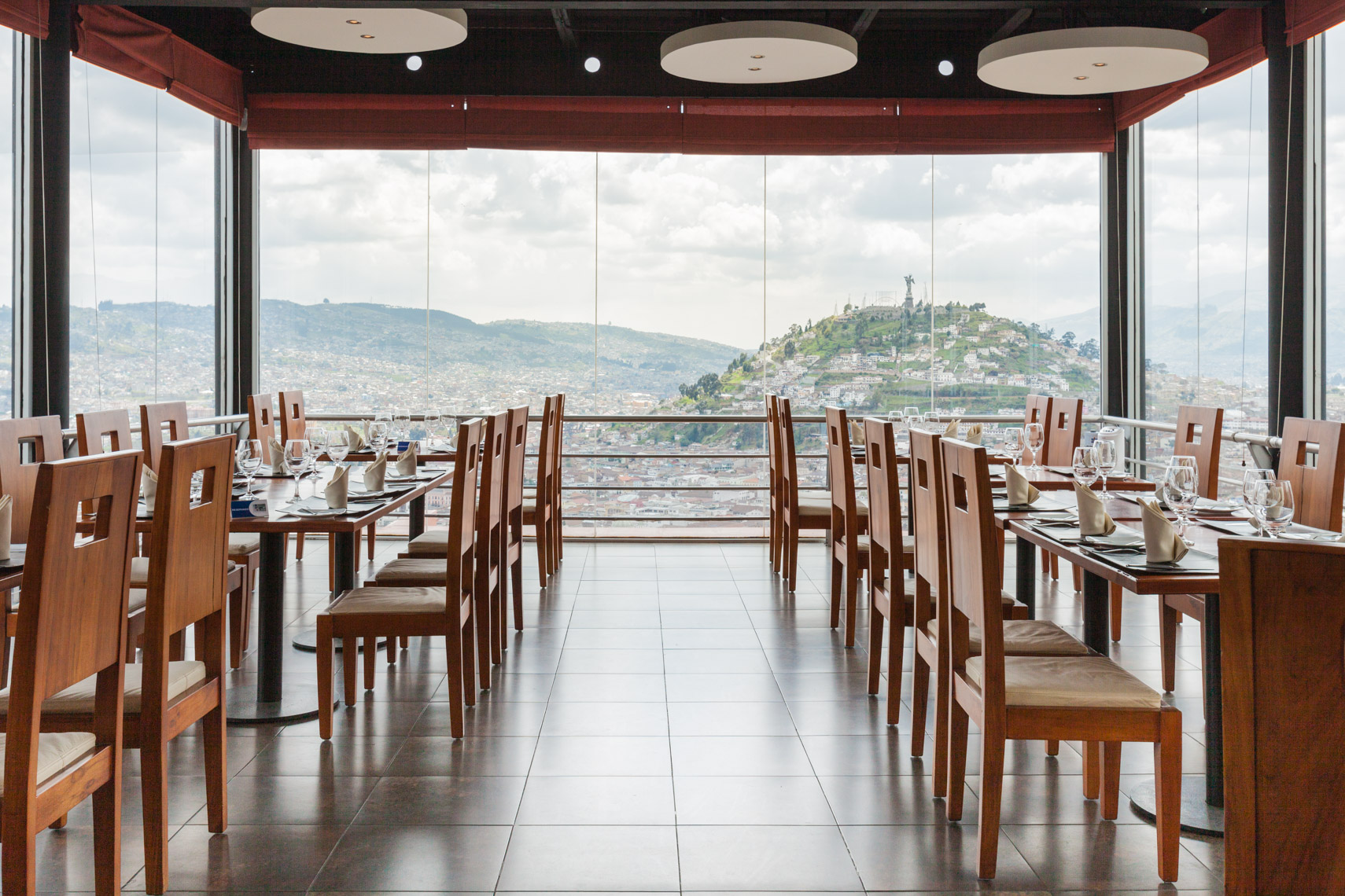Interiors of glass walled restaurant overlooking mountain vista