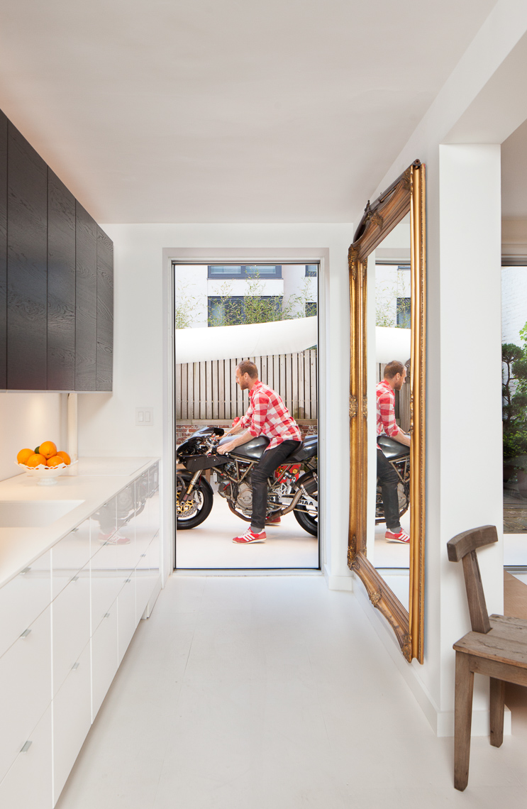 Straight view of modern kitchen with person on motorbike in backyard patio