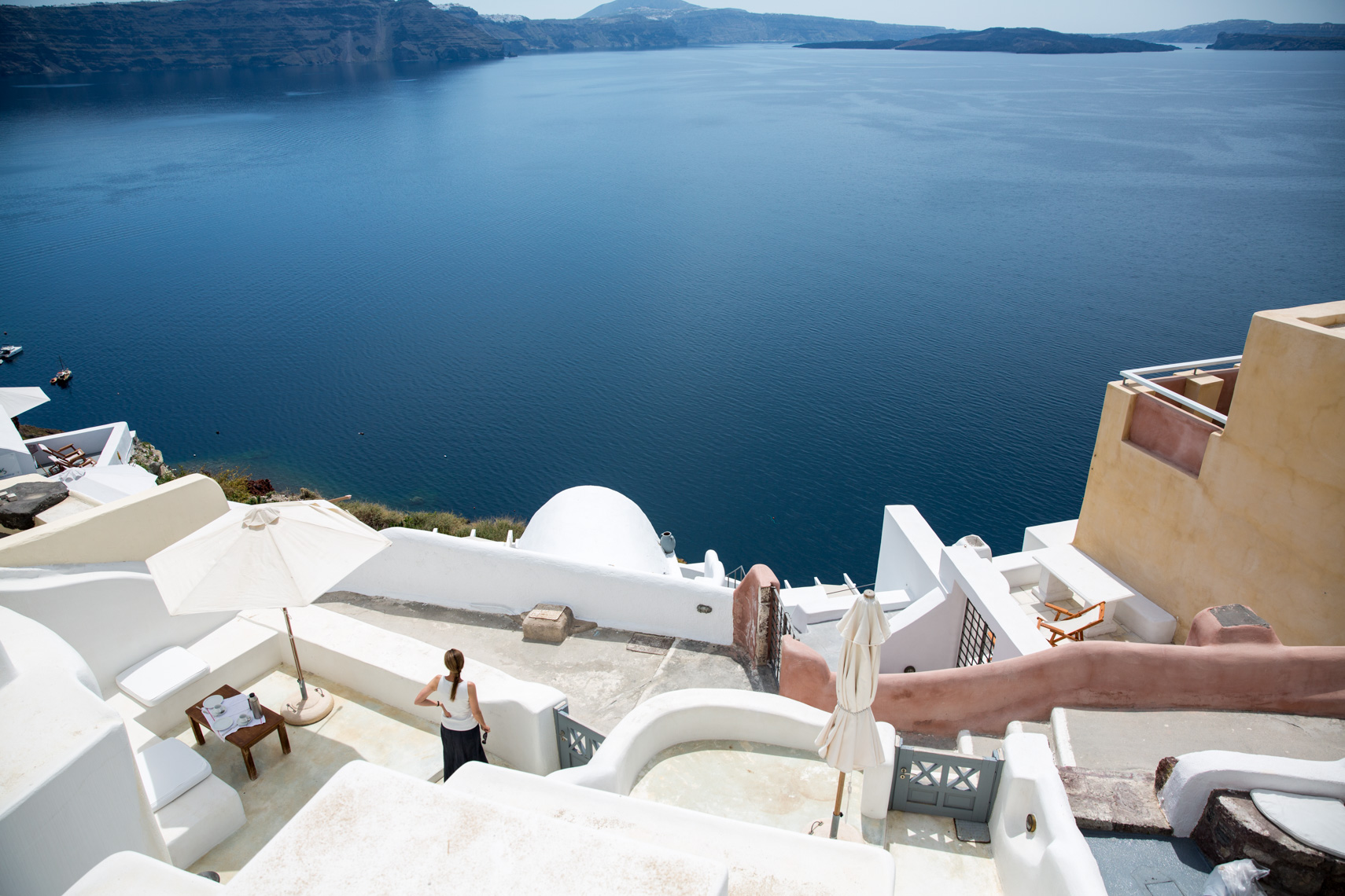 Woman in upscale luxury resort  looking at blue waters of the Aegean Sea