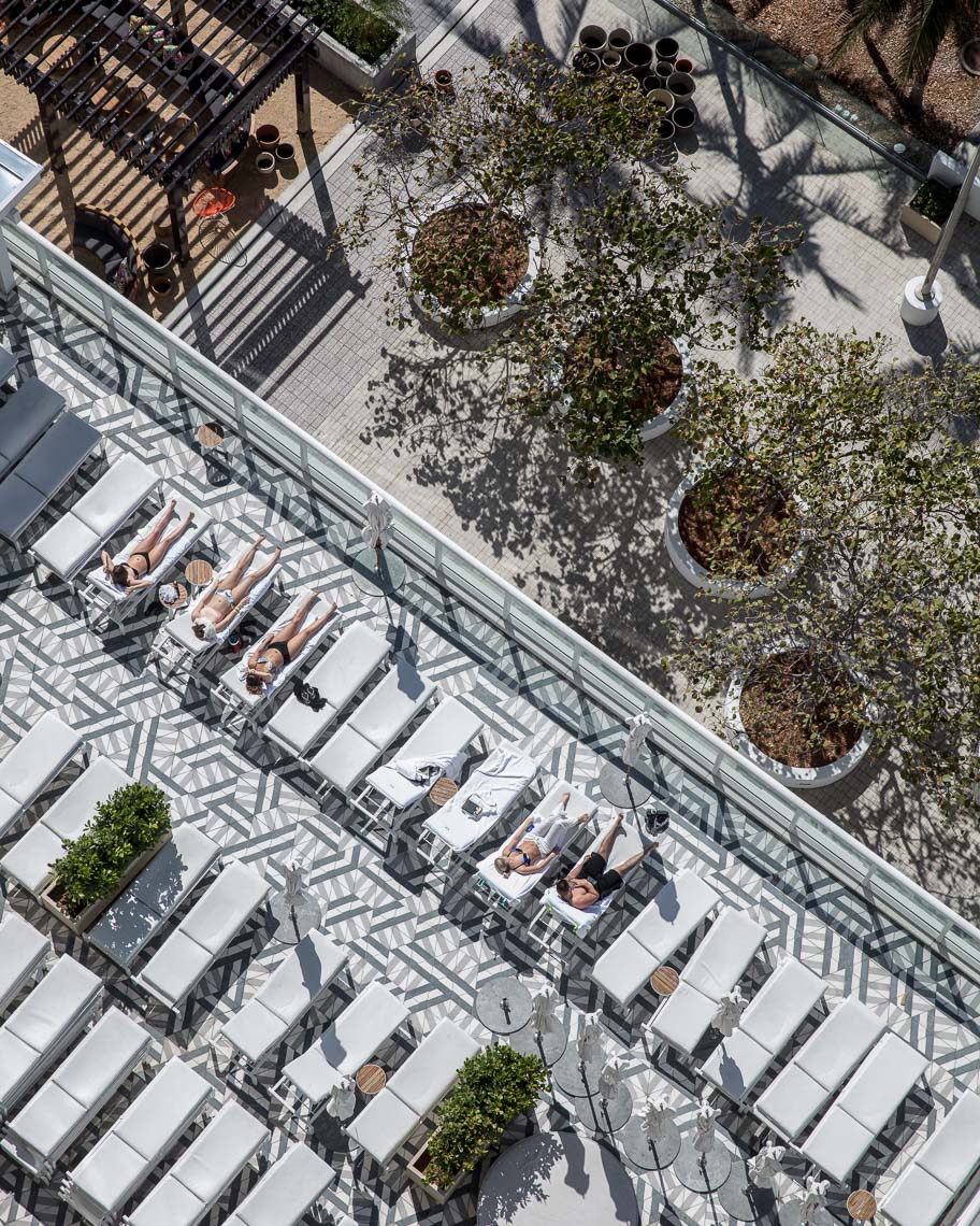 Overhead shot of sunbathers on luxury hotel patio