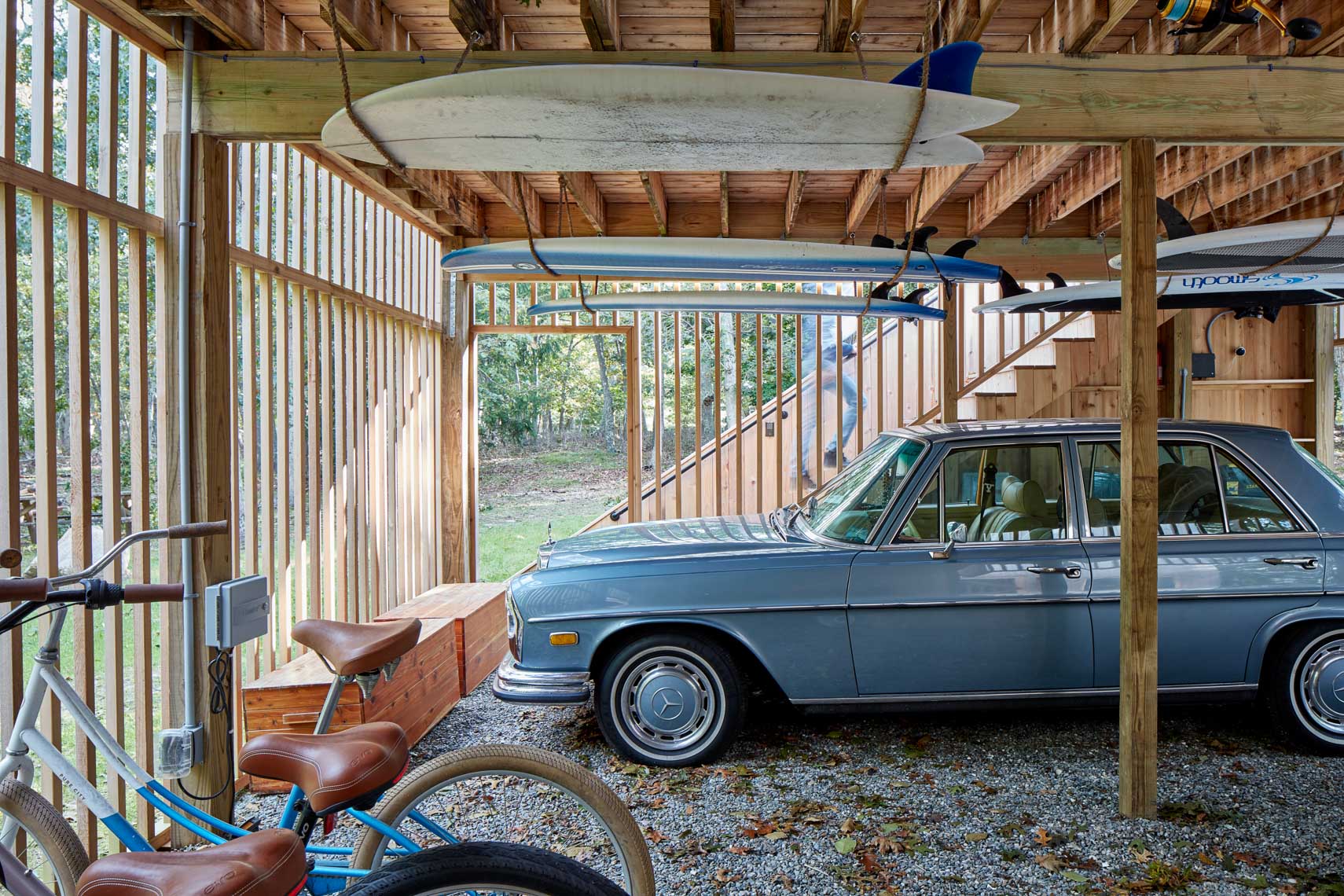 Classic Mercedes Benz in garage with surf boards hanging overhead