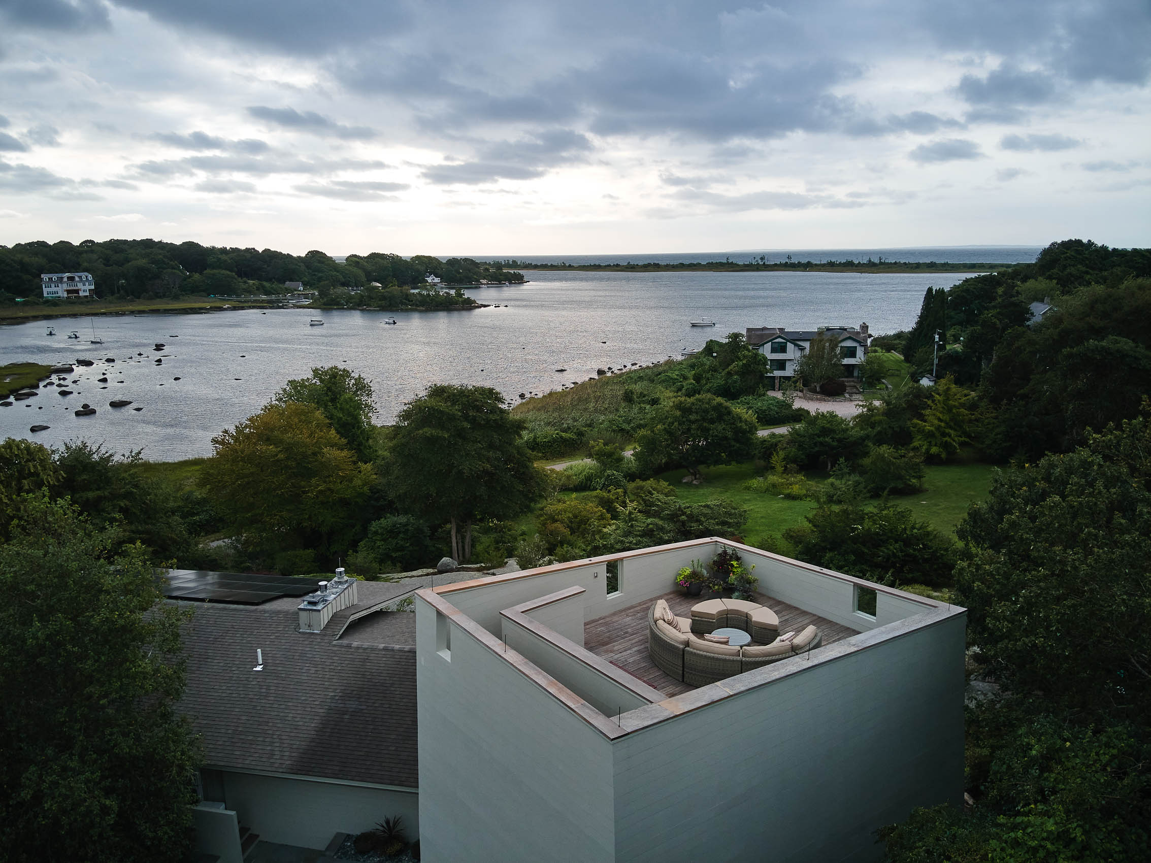 Aerial photograph of roof deck on modern house overlooking a lush green coastline  in New England