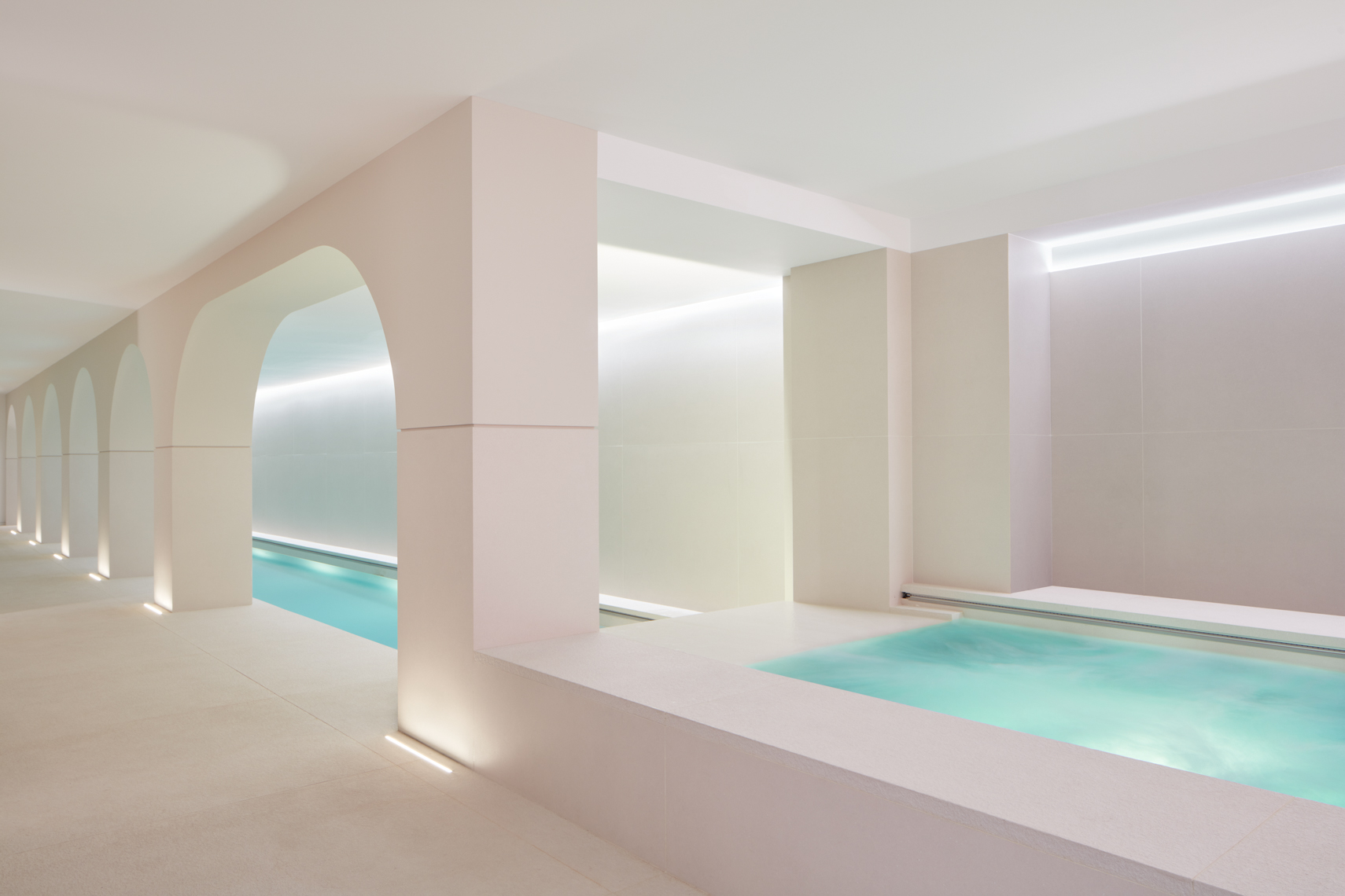 Brightly lit swimming pool with arched interior columns