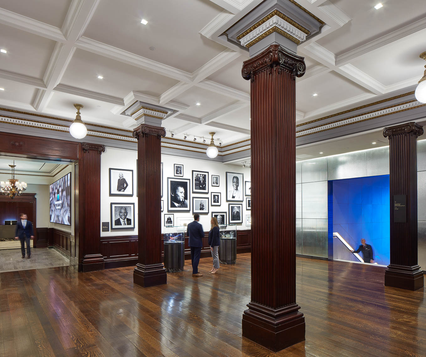 Interiors of common area with traditional wood carved columns and photographs of business leaders on the wall