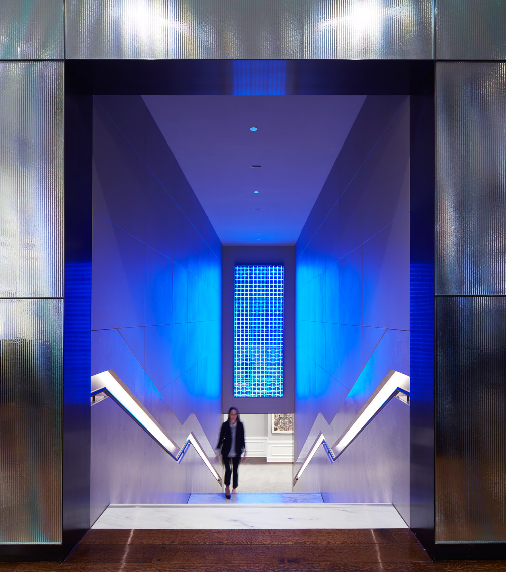 A stunning gilded staircase entryway with blue light LED art